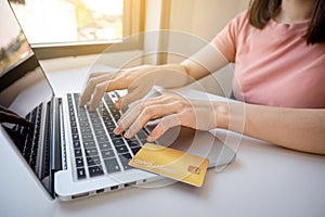 Consumer woman hand using laptop for online shopping according to discount products from home and spending pay via credit card