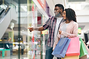 Consumerism Concept. Happy Black Spouses Shopping Together In Department Store