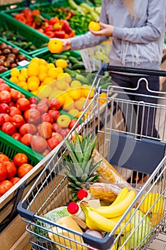 Consumerism concept. Woman doing grocery shopping at supermarket