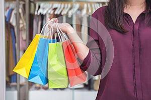 Consumerism, shopping lifestyle concept, Young woman standing and holding colorful shopping bags enjoying in shopping