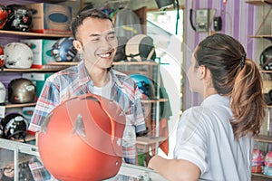 Consumers chat with shopkeepers when choosing a helmet