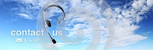 Contact concept , headset on blue sky, and contact us text