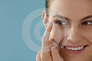 Contact eye lens. Smiling woman applying eye contacts closeup