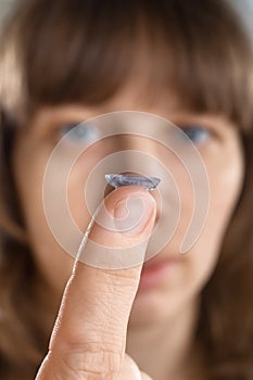 Contact lens on finger of woman (selective focus used)