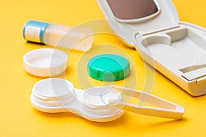 Contact lens on tweezers over an open container