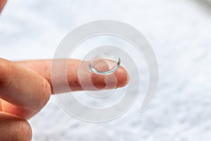 Contact lense on finger to correct nearsightedness and blurred vision eyesight by optician or oculist is to handle with hygiene