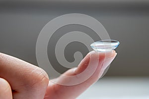 Contact lense on finger to correct nearsightedness and blurred vision eyesight by optician or oculist is to handle with hygiene