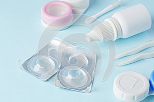 Contact lenses and accessories with solution on blue background