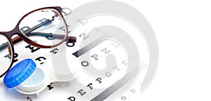 Contact lenses case and eye glasses on and eye test chart. Vision concept. Way to improve vision