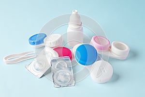 Contact lenses and cases with eye drops bottle on blue background