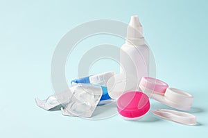 Contact lenses with cases and solution bottle on blue background