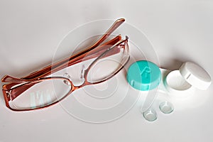 Contact lenses with container and glasses on a white background. The topic of medicine and health care. Close-up