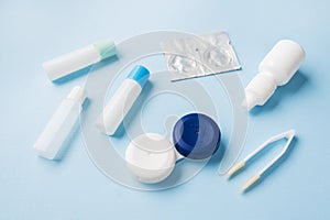 Contact lenses, tweezers and a container for storing lenses, containers for solution and moisturizing drops. Close up. Selective