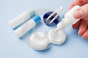 Contact lenses, tweezers and a container for storing lenses, containers for solution and moisturizing drops. Close up. Selective