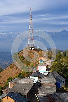 Contact mobile tower at high hilly village of Ashapuri in Himachal Pradesh, India with snow mountains in the backdrop