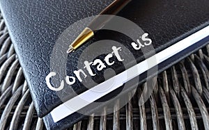 Contact us concept with agenda and pen.