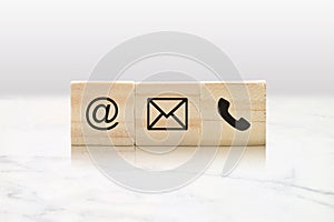 Contact Us Concept with Email, Mail and Phone Symbols on Three Wooden Blocks