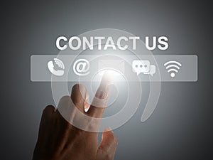 Contact us or Customer support concept. Finger tapping on a virtual screen of contact icons:  phone, address, email, live chat,