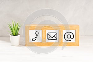 Contact us icons in modern wooden frame on desk