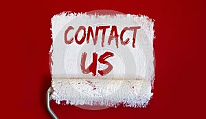 Contact Us .One open can of paint with white brush on red background. Top view
