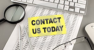 CONTACT US TODAY text written on a sticky on chart with keyboard and magnifier