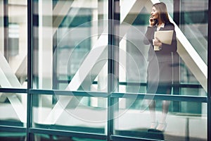 Contacting an influential client. a businesswoman using a mobile phone in a modern glass office.