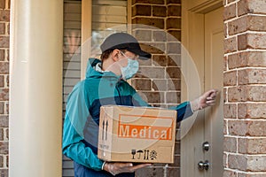 Contactless delivery during COVID-19 pandemic lockdown concept. Courier wearing mask and gloves holds a parcel