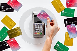 Contactless payment, paypass. Hand hold bank card near terminal on white background top-down