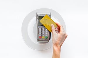 Contactless payment, paypass. Hand hold bank card near terminal on white background top-down