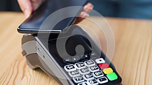 Contactless payment with smartphone. Wireless payment concept. Close-up, woman using smartphone cashless wallet NFC