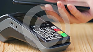 Contactless payment with smartphone. Wireless payment concept. Close-up, woman using smartphone cashless wallet NFC