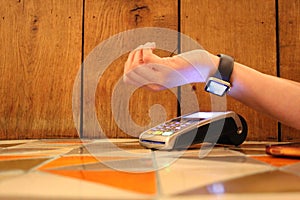 contactless payment smartwatch pdq with hand holding credit card to pay