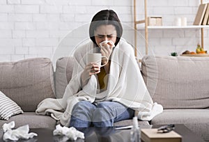 Contagious disease outbreak. Sick girl with warm drink suffering from virus at home