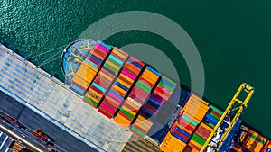 Container cargo freight ship with working crane bridge discharge at container terminal, Aerial top view container ship at deep sea