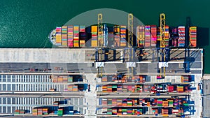 Container cargo freight ship with working crane bridge discharge at container terminal, Aerial top view container ship at deep sea