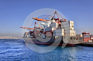 Container Cargo freight ship with working crane bridge for Logistic Import Export background