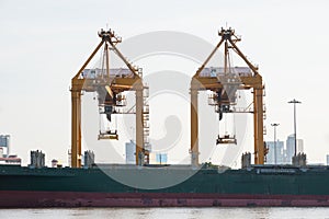 Container Cargo freight ship with working crane bridge in shipyard