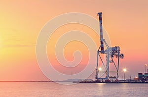 Container Cargo freight ship with working crane bridge in shipyard at dusk for Logistic Import Export