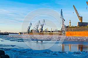 Container cargo freight ship with working crane bridge at shipyard in morning for logistic import and export background