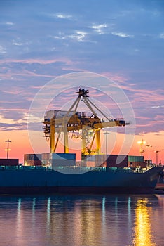 Container Cargo freight ship with working crane bridge in shipyard at sunrise