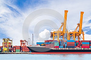 Container cargo freight ship with working crane loading bridge