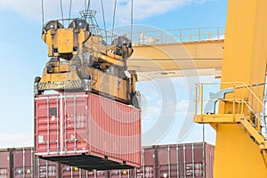 Container Cargo freight ship with working crane loading bridge i