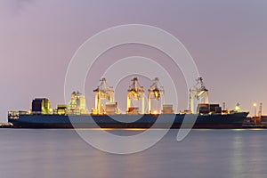 Container Cargo freight ship with working Export at twilight