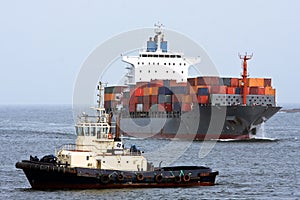 Container cargo ship with ocean tug