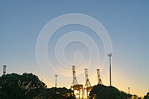 Container cranes on Port of Tauranga facility backlit by rising sun