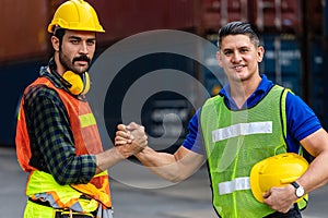 Container Depot chief  holding hands with foreman in safety vast and safety helmet