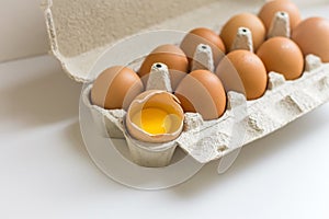 Container with eggs, one egg broken