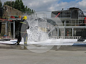 Container fire fighting training. Fire fighter spraying non aspirated foam photo