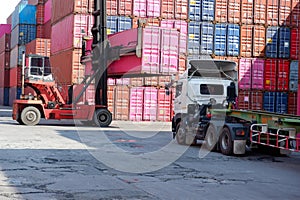 A container forklift sits behind a stack of containers