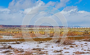 Container freight train crossing across the Canyon Diablo in the middle of the vast desert in Arizona